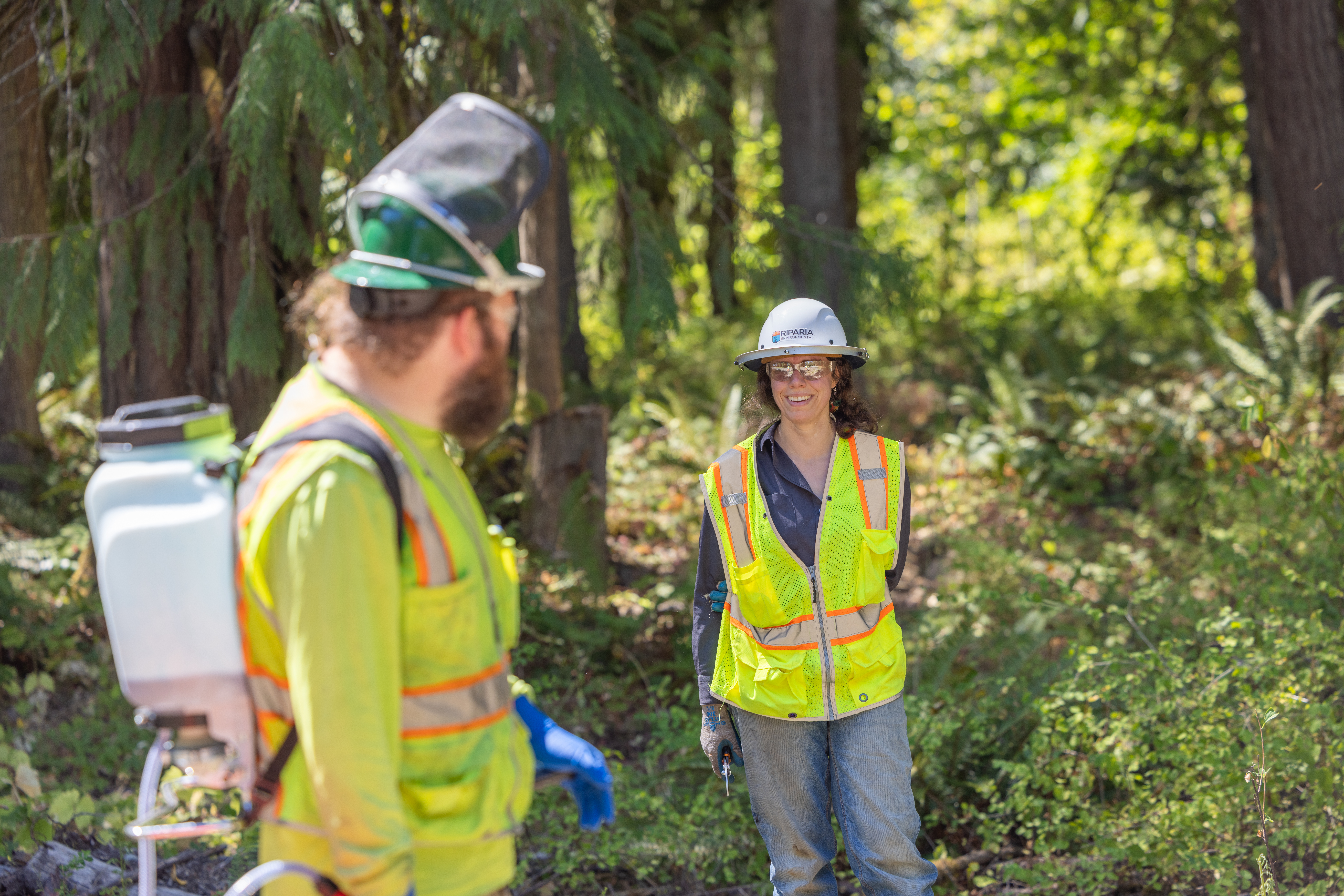 An employee laughs with a crew member in the field.
