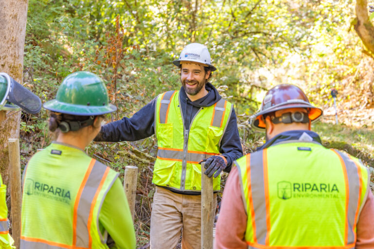 An employee laughs with his crew on-site at a project.