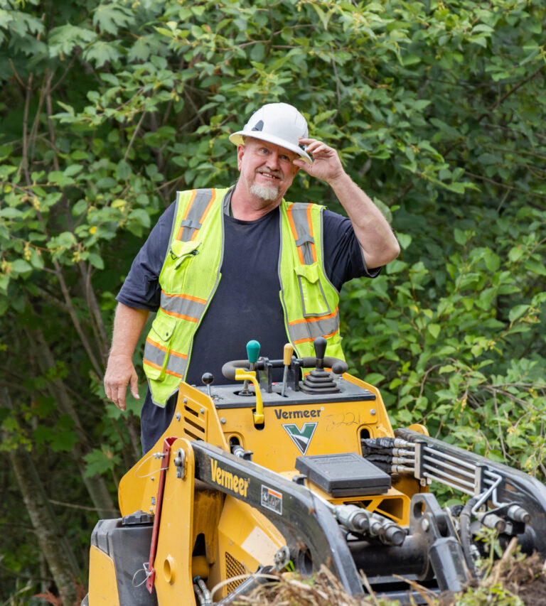 Riparia employee in safety gear operating machine