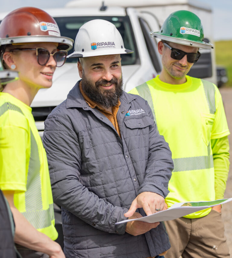 Three Riparia employees standing in front of a truck